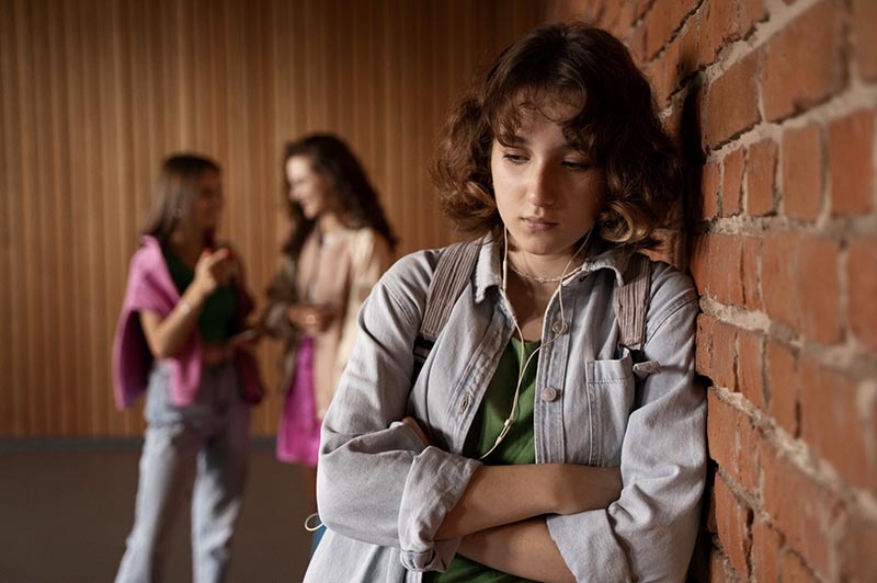 Les blessures de l'enfance - Adolescente dans un couloir de l'école qui se sent rejetée par ses camarades de classe